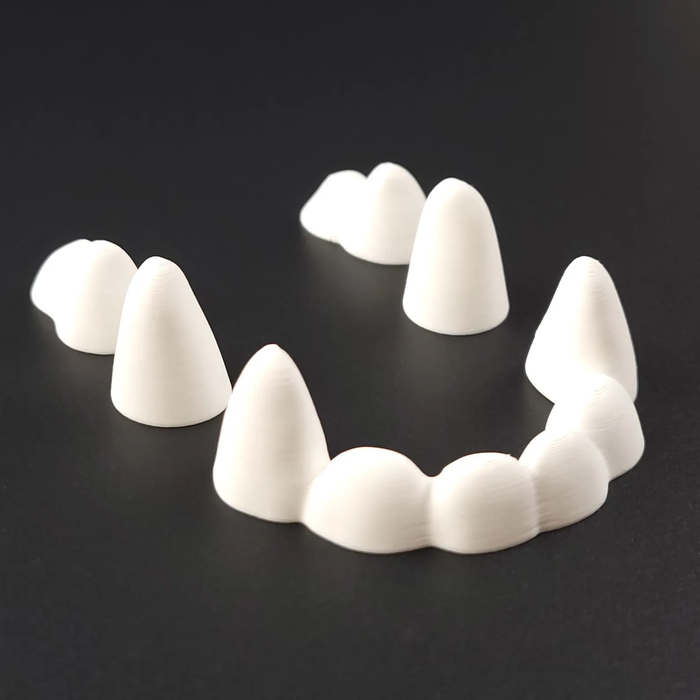 Set of white 3D-printed rounded fursuit teeth arranged like an open mouth on a black background